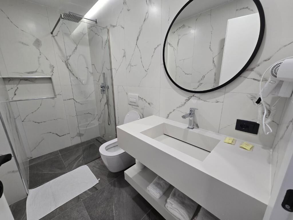 Ein modernes Badezimmer mit Dusche, Toilette und Waschbecken.