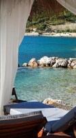 Playa privada, arena blanca, camas de playa, sillas reclinables de playa