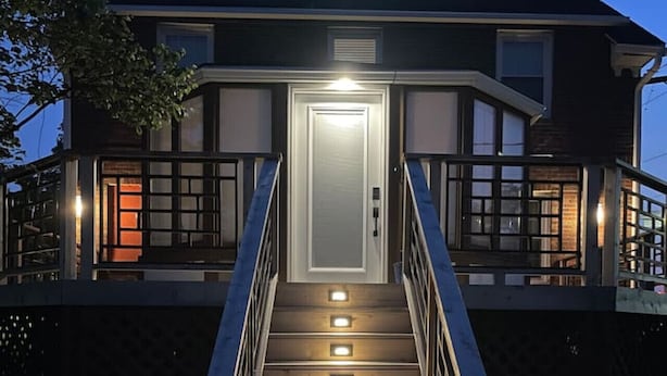 A staircase leading to a house with a lit entrance and a balcony. - Game Room/Foosball/3BD/Families/Coffee Bar/Poker (Des Moines)