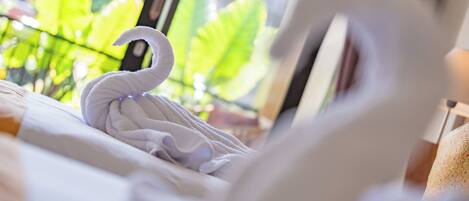 A bed with a white swan-shaped towel.