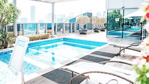 A rooftop pool area with lounge chairs and a view of the city skyline. - Modern 1BR in J One Pool & Gym (Dubai)