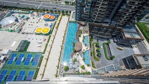 Ein Hochhaus mit Pool und Tennisplätzen auf dem Dach.