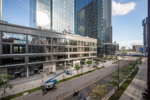 Un edificio moderno con ventanas amplias y techo plano, rodeado de una acera bien cuidada y una calle.