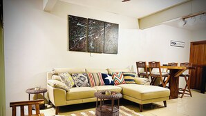 A living room with a sofa, chairs, a dining table, and a rug. - Kazafibi B4 - Steps away from the beach (Flic en Flac)