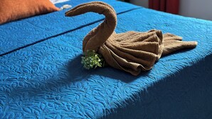 A bed with a blue quilt and a swan-shaped towel on it. - Kazafibi B4 - Steps away from the beach (Flic en Flac)
