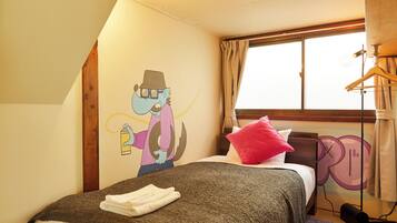 A bedroom with a bed, a wall mural, a window with curtains, and a hanging light fixture.