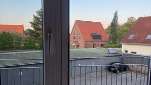 A balcony with a view of a parking area and buildings.