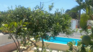 Un quartier résidentiel doté d’une piscine, entouré d’une végétation luxuriante et de poteaux électriques.