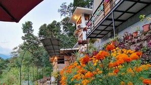 A pathway leading to a house with a balcony adorned with potted plants. - Amazing 2 bedroom house with WiFi in Gangtok A frame cottage,  peaceful place (Gangtok)