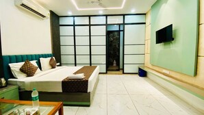 A modern hotel room with a bed, bedside table, and a TV mounted on the wall.