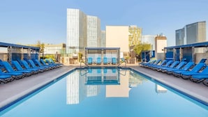 A rooftop pool with blue lounge chairs and a glass enclosure, surrounded by modern buildings. - Polo Towers Las Vegas (Las Vegas)