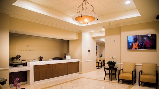 A reception area with a reception desk, seating, and a television screen. - Polo Towers Las Vegas (Las Vegas)