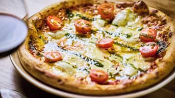 A pizza with toppings on a wooden table.