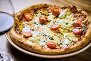 Une pizza garnie, posée sur une table en bois.