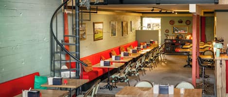 Un restaurante con una barra larga, varias mesas y sillas.
