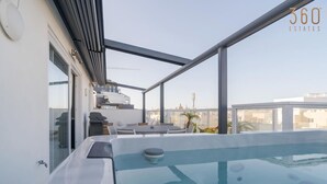 A rooftop terrace with a hot tub, seating area, and a view of the cityscape. - 2BR Penthouse Paradise w/ Jacuzzi & BBQ in Sliema (Sliema)