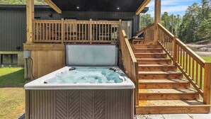 A wooden deck with a hot tub and a staircase leading to a covered area. - Spa, Mountain and River | Le Zenith (Saint-Côme)