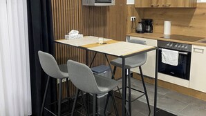 Moderni keittiö, jossa on puusta tehty korosteseinä, mikroaaltouuni, kahvinkeitin ja astianpesukone.