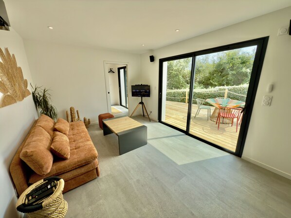 A spacious living area with a large sliding glass door leading to an outdoor deck.