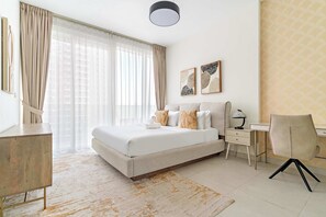 Um quarto com cama, mesas de cabeceira, escrivaninha e cadeira.