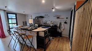 Una cocina funcional con comedor, piso de madera y vistas al exterior.