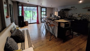 Amplia sala de estar con sofá, mesa de comedor y zona de cocina.