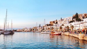 A coastal town with a marina, white buildings, and a clear sky.