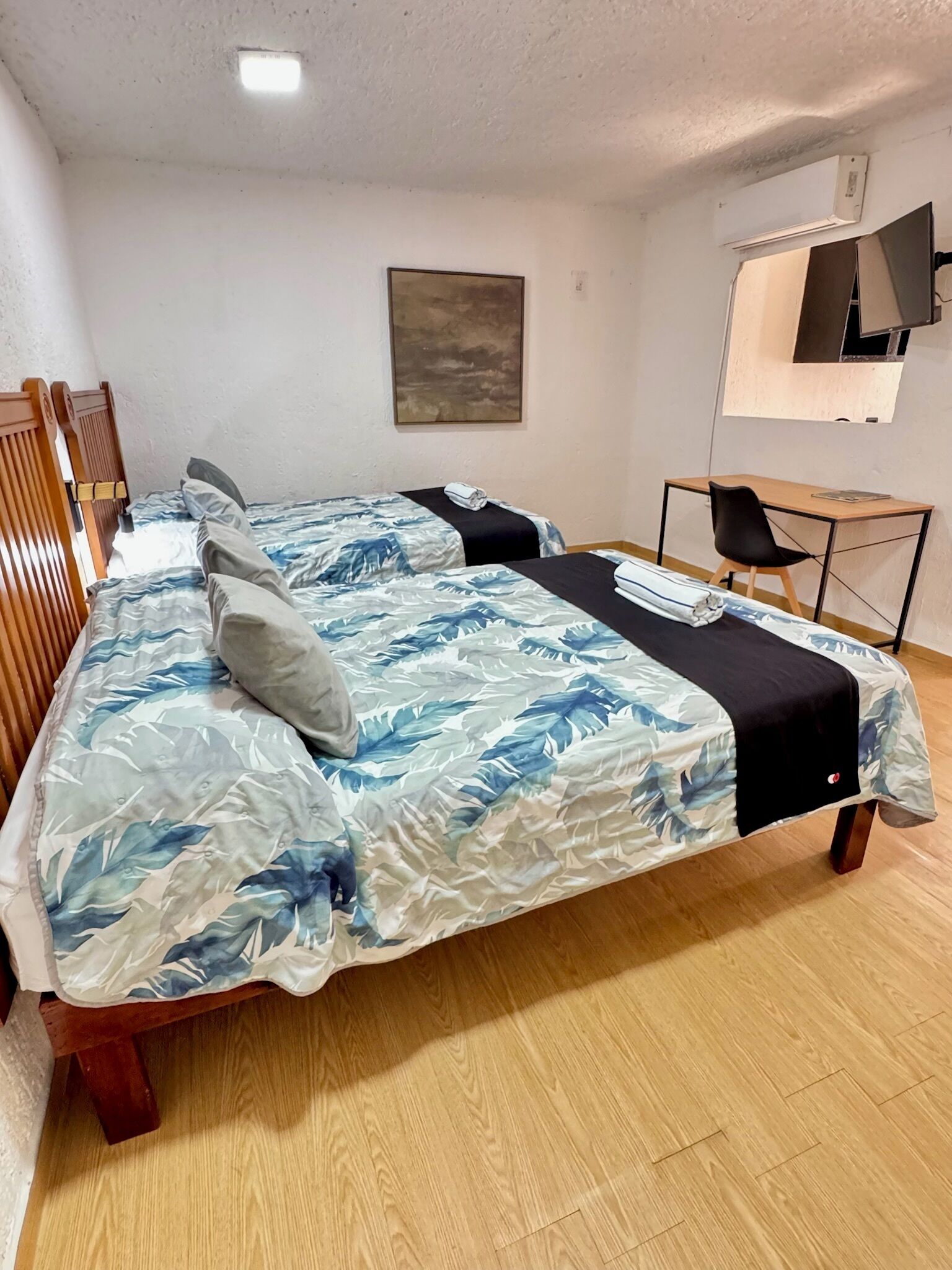 A bedroom with a bed, a desk, and a chair.