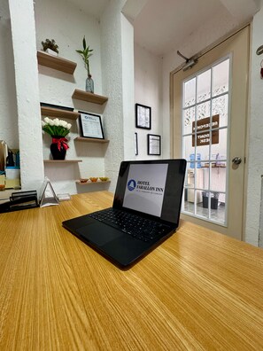 A laptop on a wooden desk with a sign for Hotel Farallon Inn. - HOTEL FARALLON INN (Cancun)