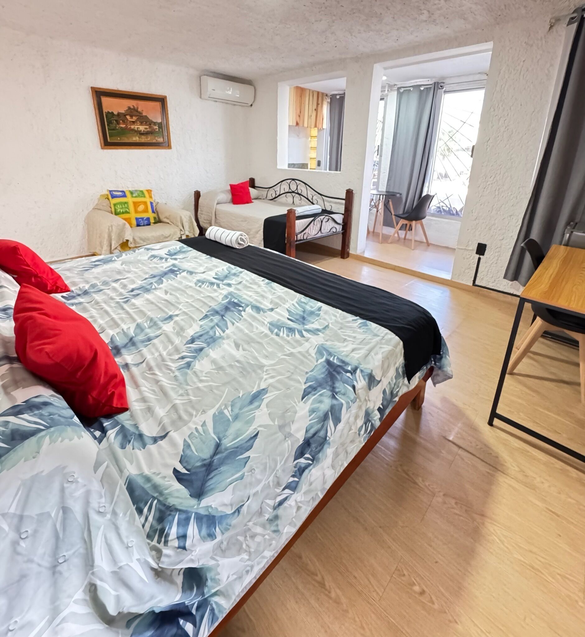 Een slaapkamer met een bed, een bureau en een stoel.