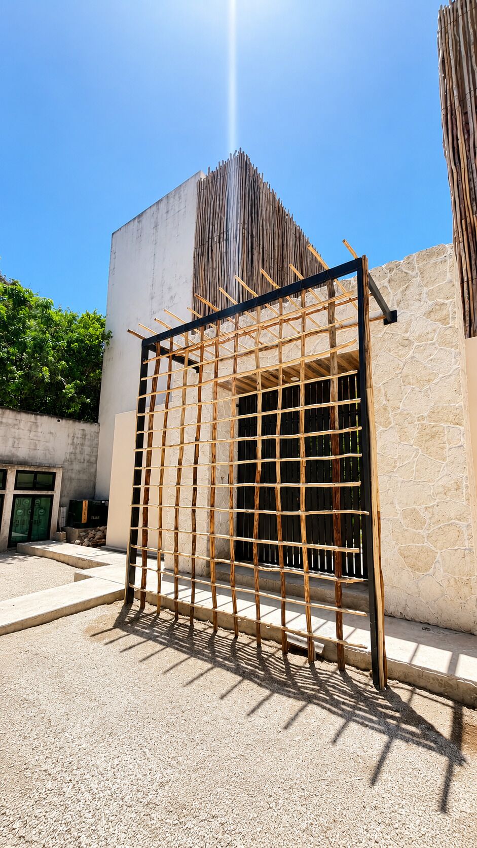 A building with a concrete exterior, a wooden gate, and a stone wall.