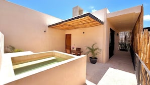 A modern outdoor patio with a pool, a wooden table with chairs, and a potted plant. -  Lapso At Tulum (Tulum)