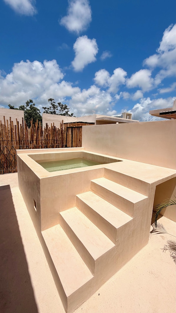 A rooftop pool with a geometric design, surrounded by a wooden fence and a clear blue sky. - Lapso At Tulum (Tulum)