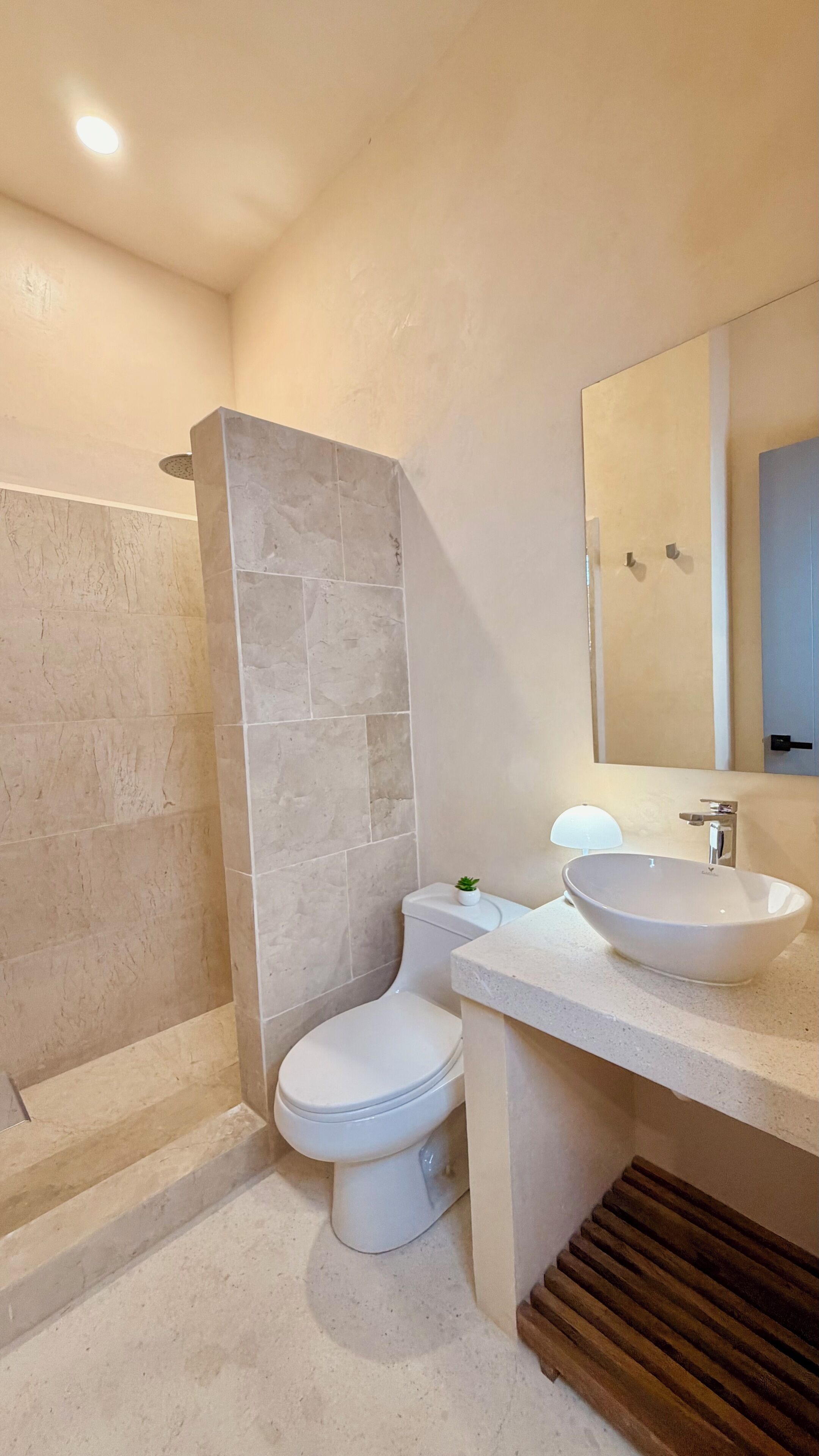 Ein Badezimmer mit Dusche, Toilette und zwei Waschbecken.
