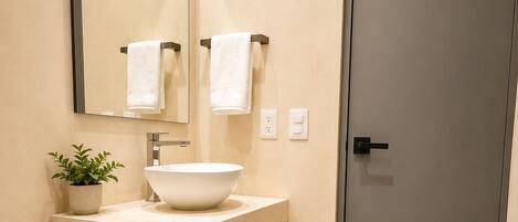 Une salle de bain moderne avec des toilettes, un lavabo et un miroir.
