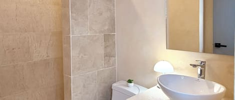 Une salle de bain moderne équipée de toilettes, d’un lavabo et d’une douche.