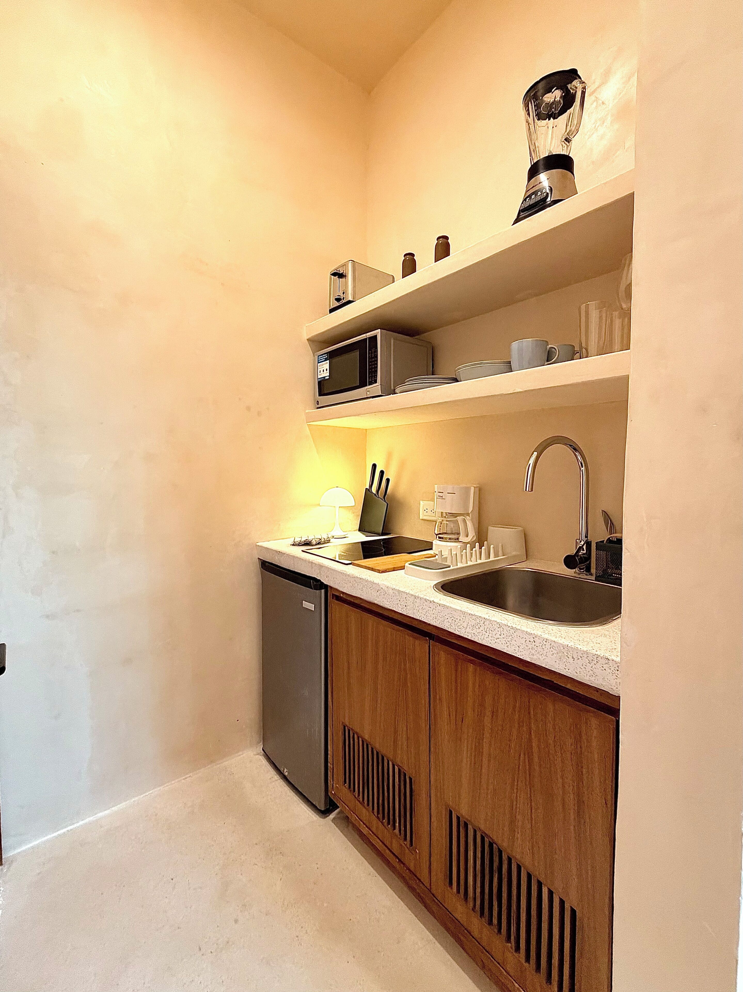 A compact kitchen with a dishwasher, microwave, sink, and wooden cabinets.