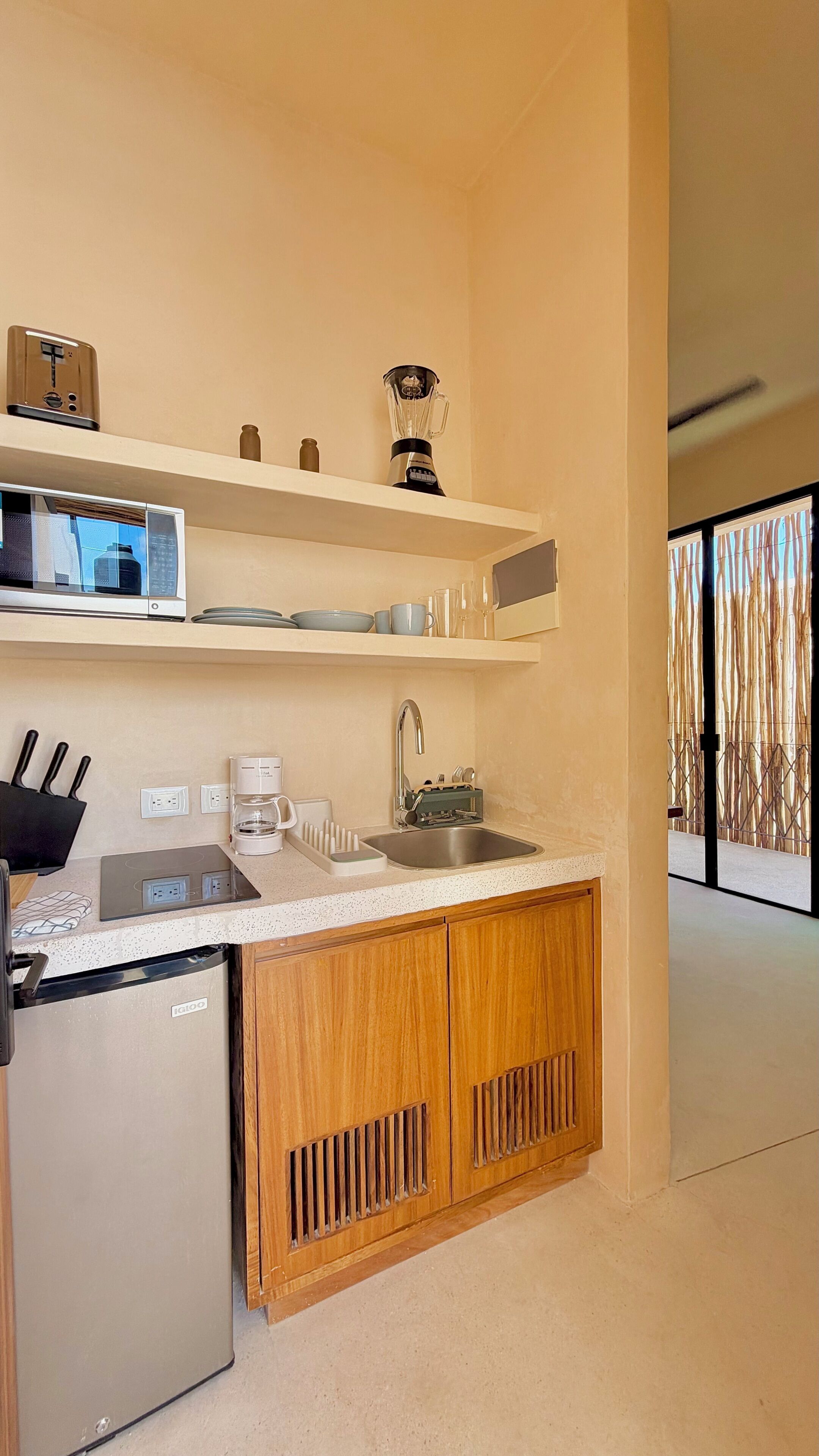 Una cocina moderna con un refrigerador de acero inoxidable, una cafetera y un lavamanos.
