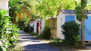 A narrow road flanked by colorful mobile homes with a clear sky above. - Mobile Home Camping for 4 in Vias (Vias)