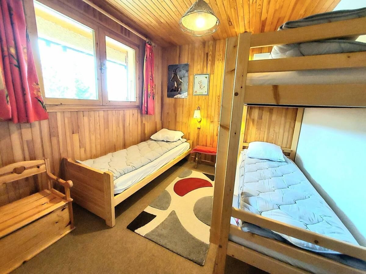 Een houten kamer met stapelbedden, een tafeltje en een lamp.