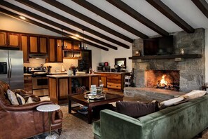A modern kitchen with wooden cabinets and a stone fireplace.