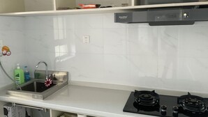 A kitchen with a sink, stove, and cabinets.