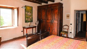 Une chambre à coucher avec un lit, une armoire en bois et une chaise.