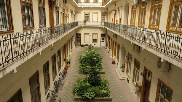 A courtyard with a central garden, balconies with wrought iron railings, and multiple windows with wooden frames. - Sidi Studio - left side, right in the heart of Budapest, The Sidonies Twins in Seventh (Budapest)