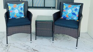Two wicker chairs with matching cushions and a small table in front of a window with closed blinds. - Charming 4-bedroom Pool house with WiFi, king bed, AC in lovely Orlando (Orlando)