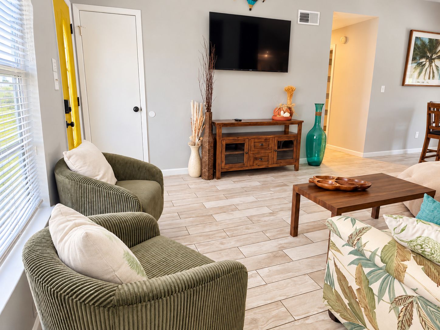 A living room with a sofa, a coffee table, a TV, and a cabinet.
