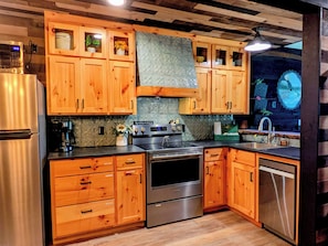 A kitchen with wooden cabinets, stainless steel appliances, and a backsplash.