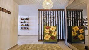 A room with a large mirror, a wooden wardrobe, and a hanging light fixture. - GOZO APARTMENT (Qala)