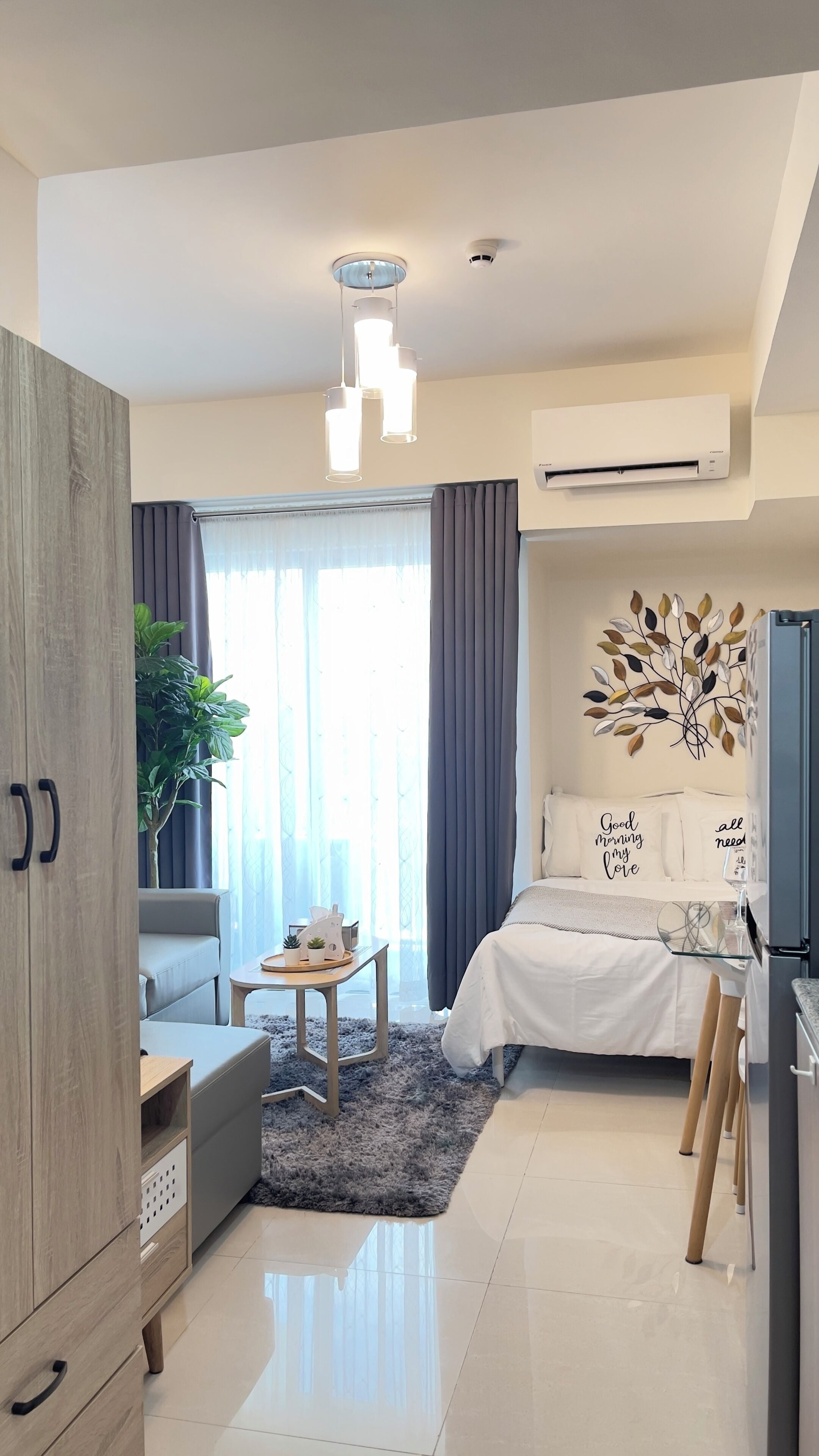 A modern bedroom with a bed, bedside table, and a decorative wall piece.