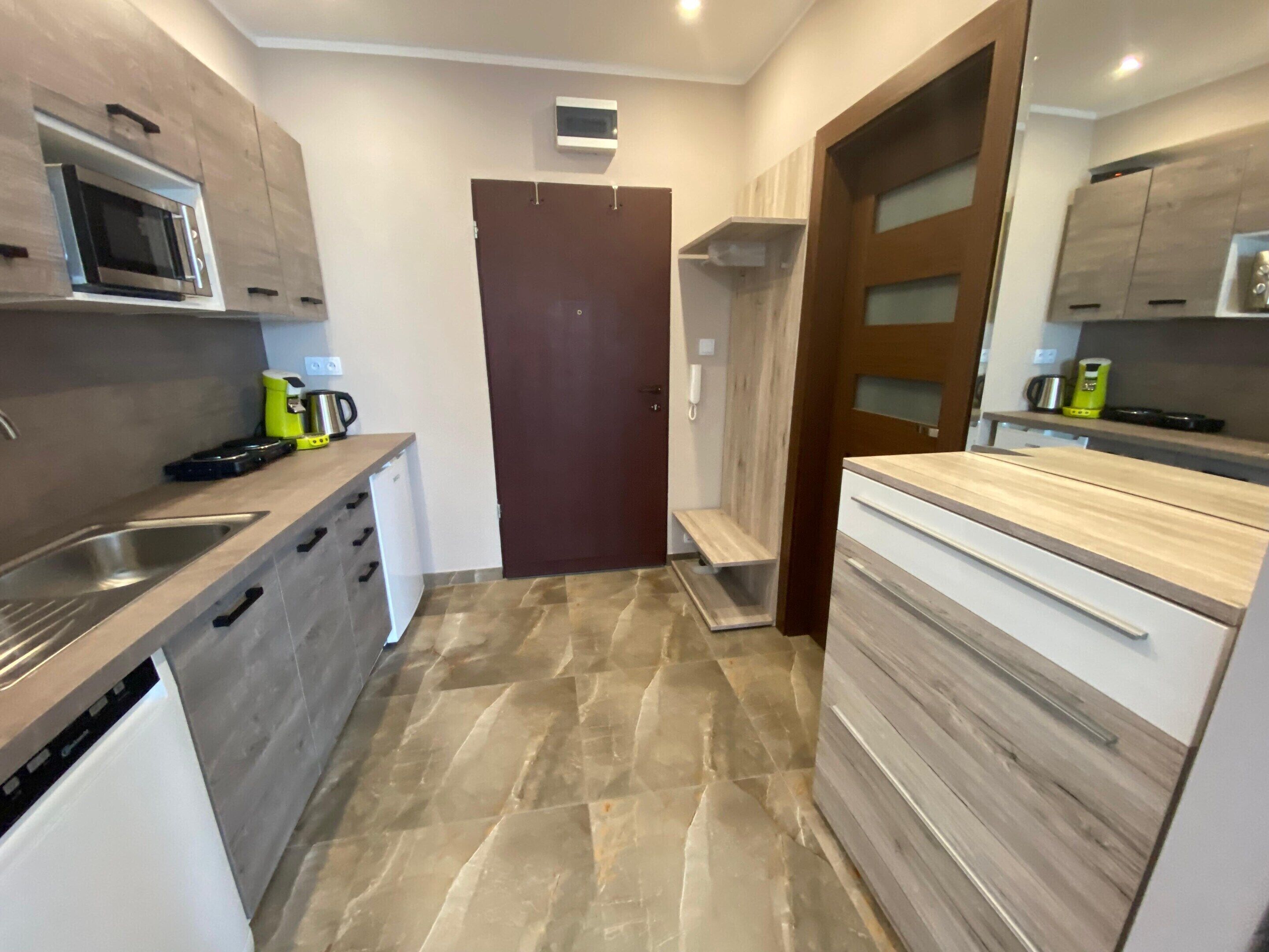 A modern kitchen with a microwave, sink, and wooden cabinets.